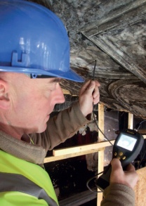 A camera probe is inserted through a tiny hole in a plaster ceiling to view the substrate