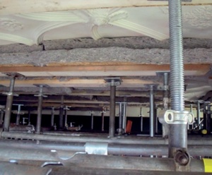 Plaster ceiling supported by props and timbers with sheep's wool insulation providing a cushion between timber and plaster 