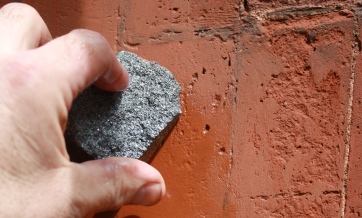 Brickwork being cleaned with a small block of carborundum and water