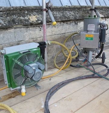 Swirling vortex abrasive system set up on scaffolding in front of a stone parapet