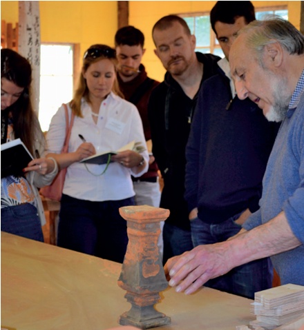 Delegates make notes while an expert discusses a terracotta baluster