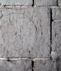 Apotropaic marks scratched into a masonry wall