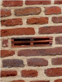 Tile access vent in historic brick wall