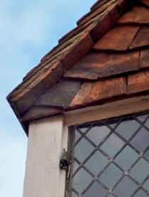 Small access gap between lower edge of hanging tiles and timber upright of dormer face