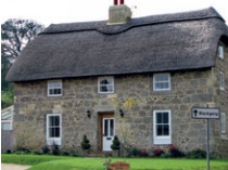 Sandstone facade of thatched cottage