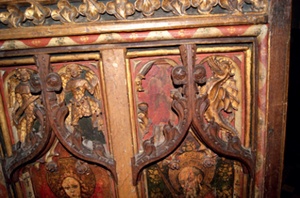 Detail of intricately carved and painted panel including figures of angels, dragon and floral motifs