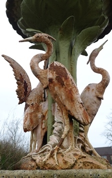 Rust-coated cast iron herons before restoration