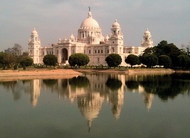 The dome and turrets of the Victoria Memorial Hall, faced in white marble, with ornamental lake in foreground