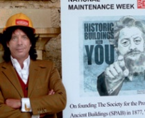 Laurence Llewelyn-Bowen in SPAB hard-hat beside a poster advertising SPAB's National Maintenance Week