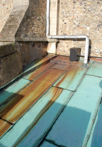 Brown iron staining to area of copper sheet roofing below overflow pipe