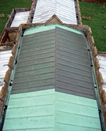 Church roof (viewed from above from church tower) showing very marked difference between old, patinated copper sheet and area of new copper sheet