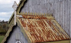 Corrosion to corrugated iron roof and decorative ridge piece on a chapel entrance porch