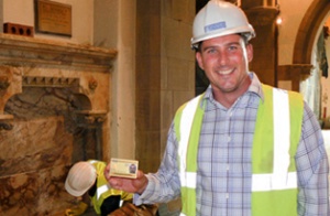 A conservator on site holding up his heritage skills card