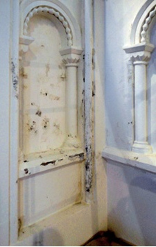 Surface paint loss and damp staining to an overpainted blind arch