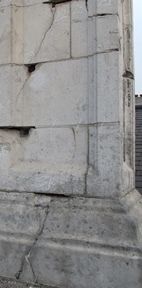 Localised spalling and long, fine cracks caused by rusting masonry cramps
