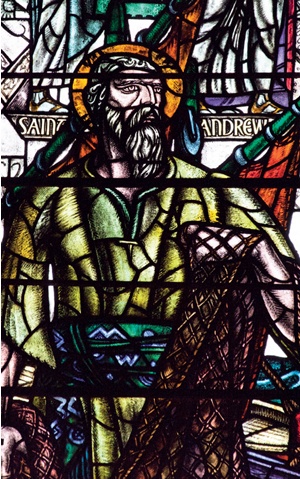 The bearded and haloed figure of St Andrew hauling in a fishing net