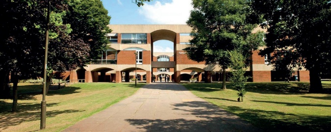 The red brick and concrete facade of Falmer House: a large open quadrangle is visible through the high central arch
