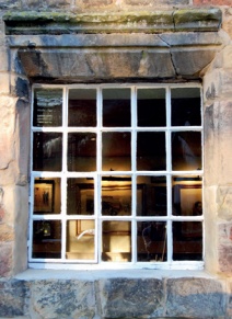 Single glazed cast-iron window in stone surround