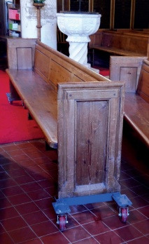 Pew mounted on a steel-framed 'skate' with large caster wheels