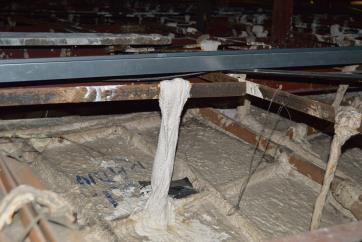 Close-up of wadding tie and wire loop attaching reverse of suspended plaster ceiling to the frameork above it