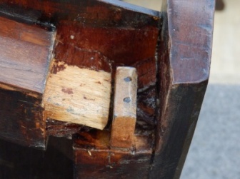Close-up of underside of chair seat showing repaired tenon and filed heads of two carbon fibre rods