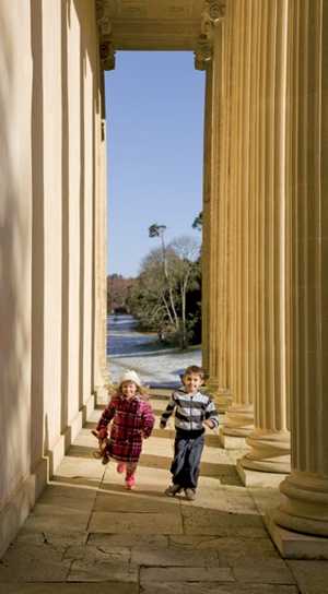 Children running through stone colonnade