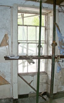 Decayed sash window and shutters in historic interior undergoing refurbishment