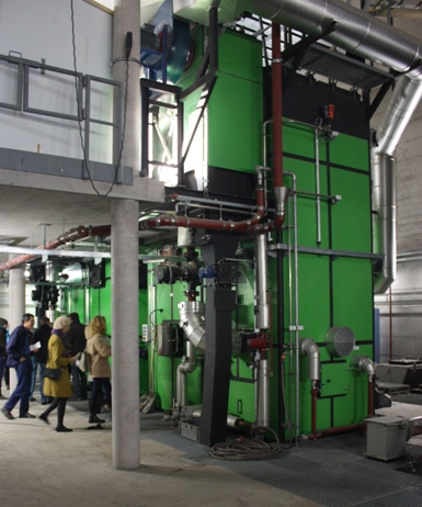 Visitors inspect machinery at a biomass heating plant