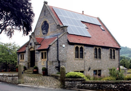 Converted historic chapel with large array of solar PV panels on roof