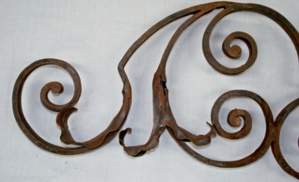 Badly rusted section of iron gates incorporating curled leaf design