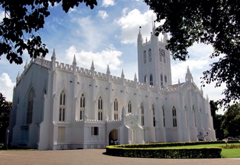 St Paul’s Cathedral, Kolkata: the white-painted exterior with well tended gardens in right foreground