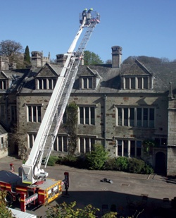 Firefighters use an extendable ladder as part of a fire drill at Lanhydrock