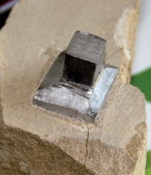 Close-up of test piece with three cracks in stone base radiating from over-caulked joint