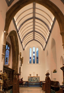 LED strips illuminate the vaulted chancel ceiling and miniature LED spotlights uplight the mullions of the east window