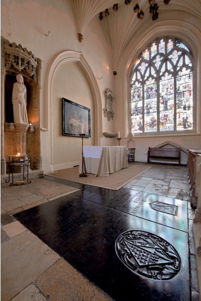 Polished black ledger stones with altar and stained glass window in background