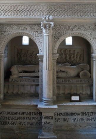 Ornately carved stone tomb with effigy and Latin script