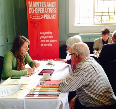 Two volunteers talk to an SPAB adviser at a Maintenance Co-operatives event