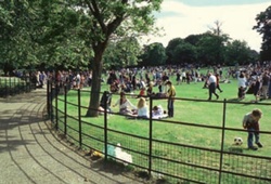 Visitors at Manor House Gardens, London with fenced off access-way in the foreground