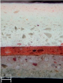 Magnified paint sample with distinct orange-red band