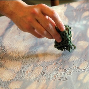 Close-up showing sponge being used to work surface glaze