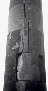 Vertical cracks and spalling on face of a stone column