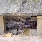 Rusting metal tie in masonry wall exposed during repair work