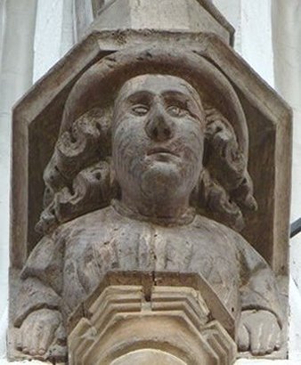 Portrait bust of male figure with wide-brimmed hat and flowing hair
