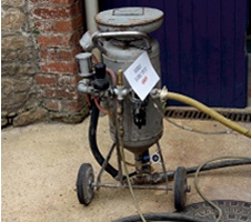 Cylindrical dry ice blasting unit mounted on trolley-like undercarriage