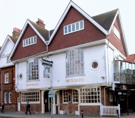 Front facade of the Tabard Inn with tile-hung, roughcast rendered and brickwork stages