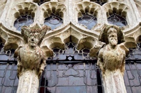 Medieval stone carvings adorn the mullions of a church window