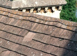 The location of a missing tile is visible near the ridge of a church roof