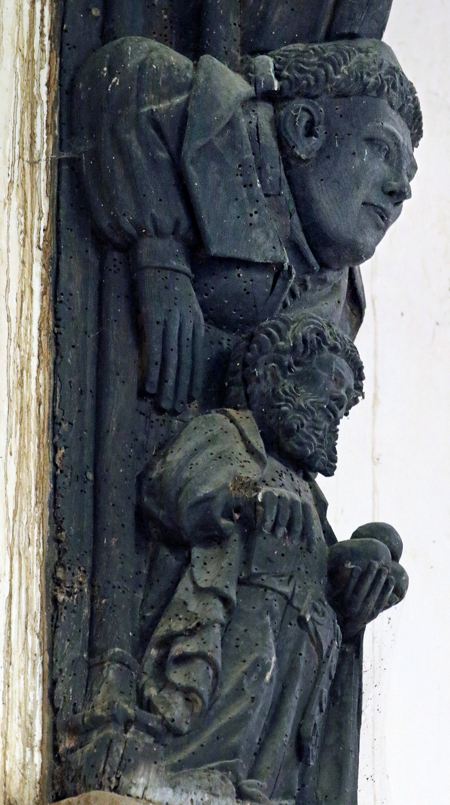 Details of some of the double figures on the roof posts with an apostle on each: a demon with St John