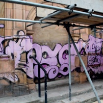 Large pink graffiti tag across historic terracotta facade