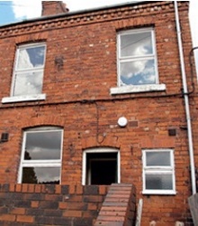 Red-brick terraced house with unsympathetic uPVC windows 